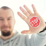 Thanks, but no thanks photography of a persons hand with stop signage