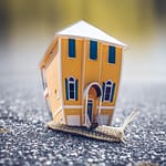 Moving! microphotography of orange and blue house miniature on brown snail s back